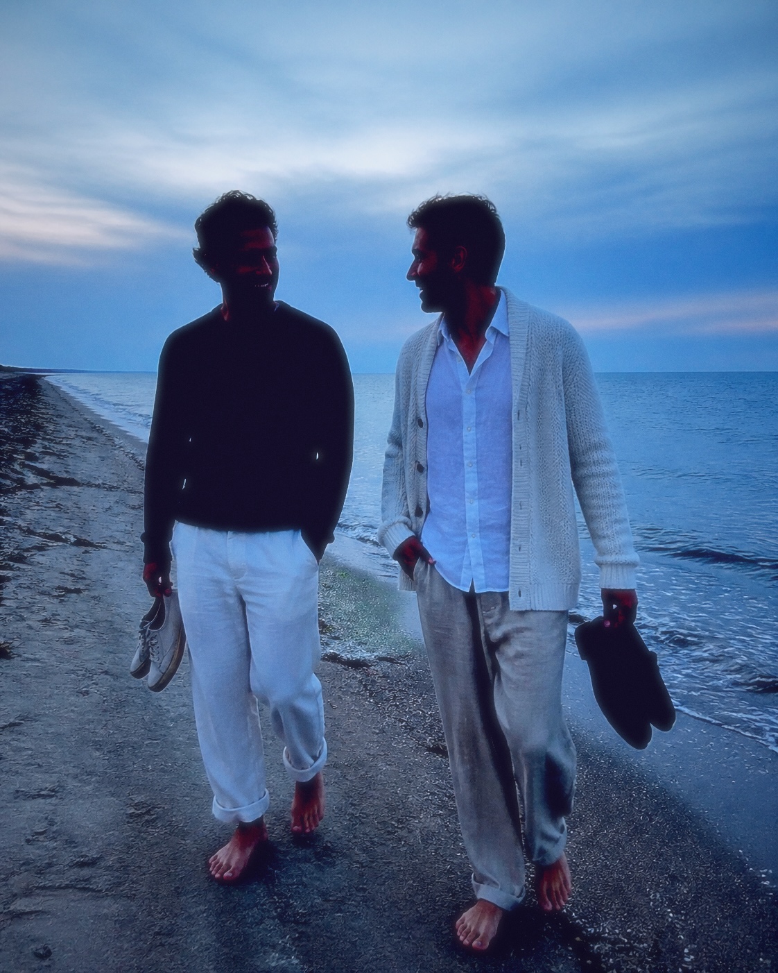 Two adult friends walking a beach after sunset, finished with Fold III.